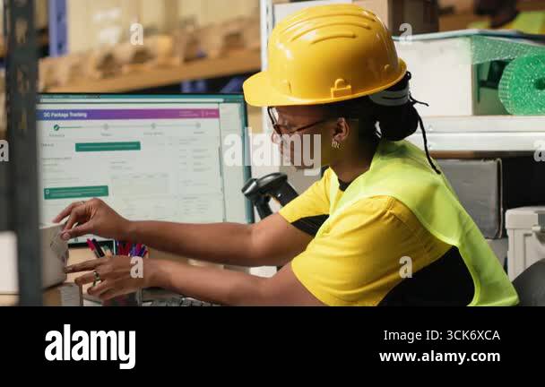 Black worker applying and scanning barcodes awb tags on cargo boxes ...