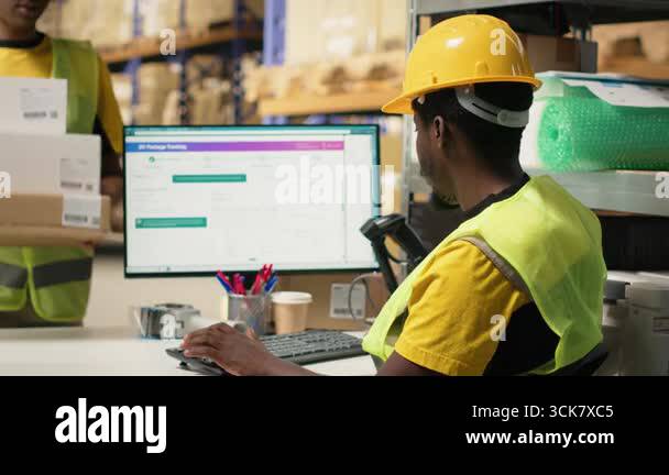 Black staff member using a barcode scanner to process shipping labels ...
