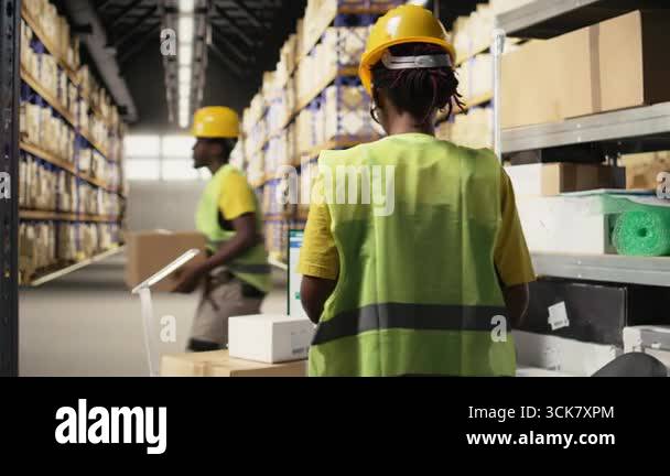 African american warehouse clerk overseeing package route to update ...