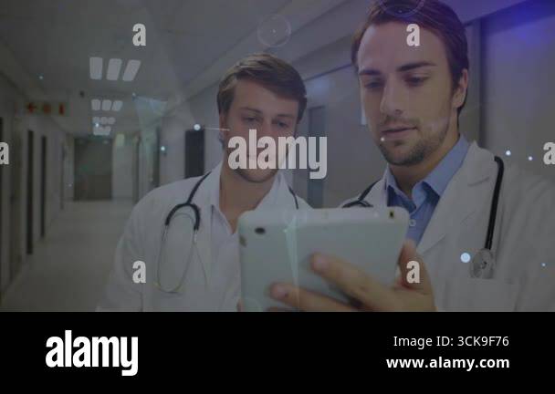 Doctors in hospital tapping, scrolling tablet and activating data ...