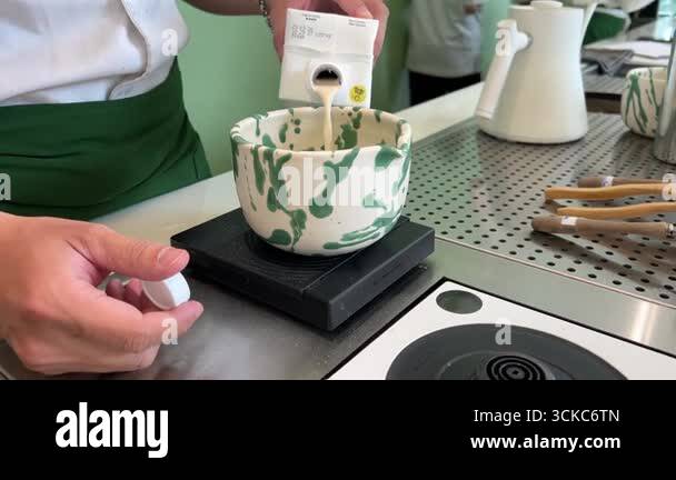 Matcha tea crafted by woman whisking fine green tea powder in ...