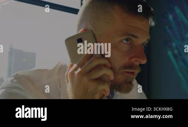 Mid male IT holding smartphone to ear while reviewing growing network ...