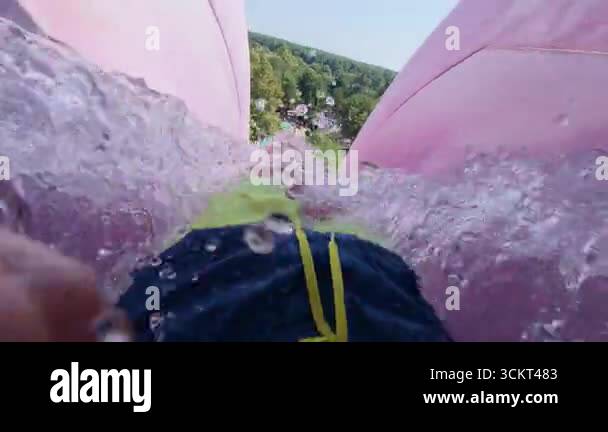 POV of an extreme free fall ride down a tall vertical waterslide. High ...