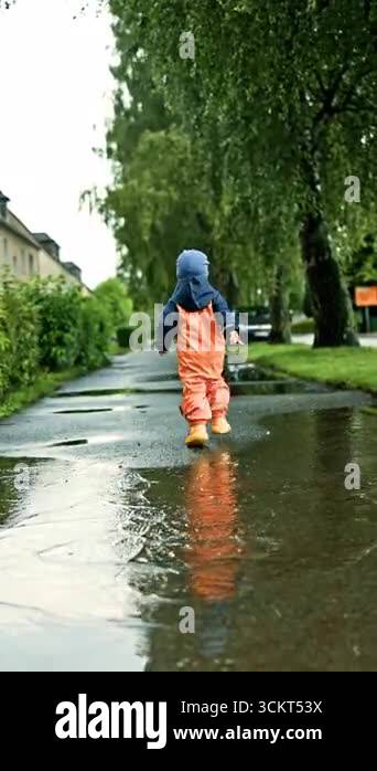 Video of happy little boy in rubber boots running and playing in a big ...