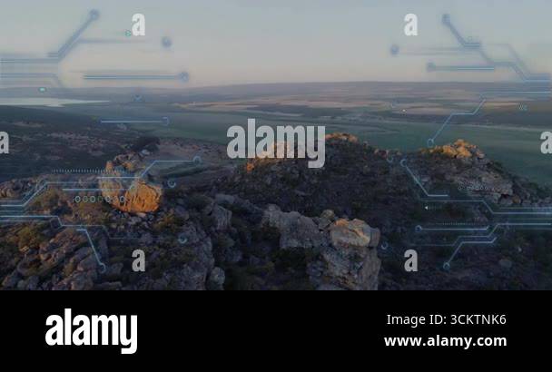Camera backing and tilting upward from outcrop revealing valley lake ...
