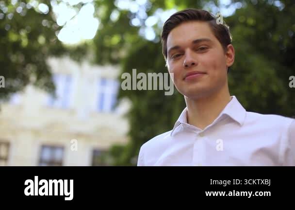 Portrait of a young handsome businessman student look at camera smiling ...