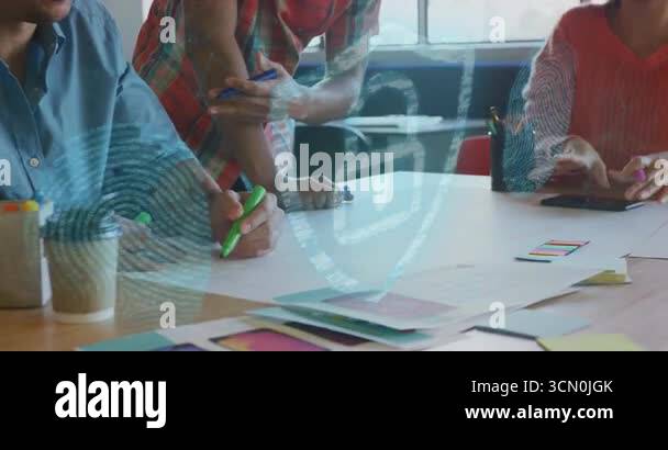 Picking green highlighter, UX team sketching UI mockups at table ...