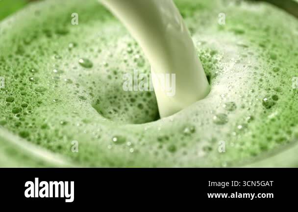 Super Slow Motion Detail Shot of Pouring Cream into Matcha Latte with ...