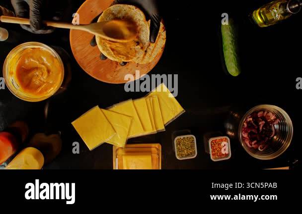 The chef spreads sauce on fresh hamburger buns. Top view of the chefs ...