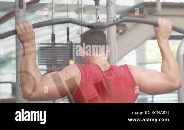 Male exerciser initiating lat pulldown by gripping curved bar, engaging ...