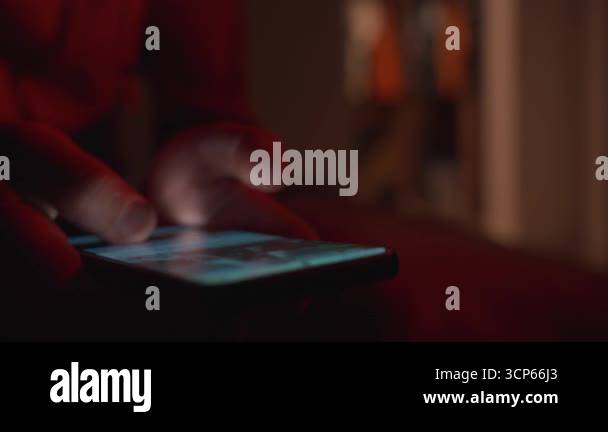 Man using smartphone at night. Close up of hand holding smartphone ...