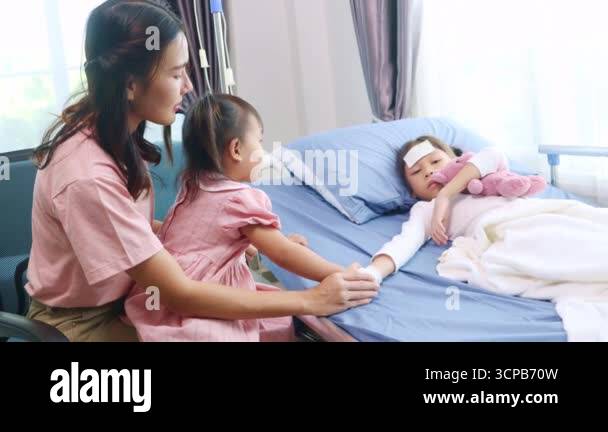 Mother cares for her daughter who is sick with the flu virus while ...