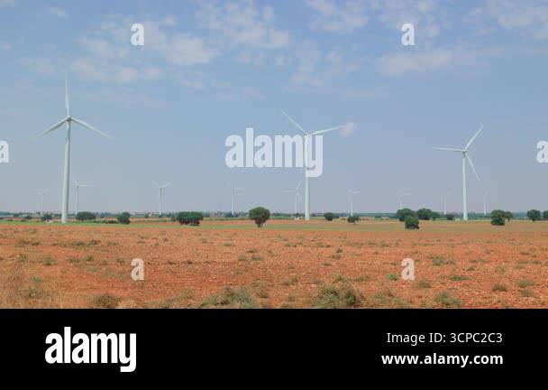 Rotating wind turbines in open rural landscape with multiple windmills ...