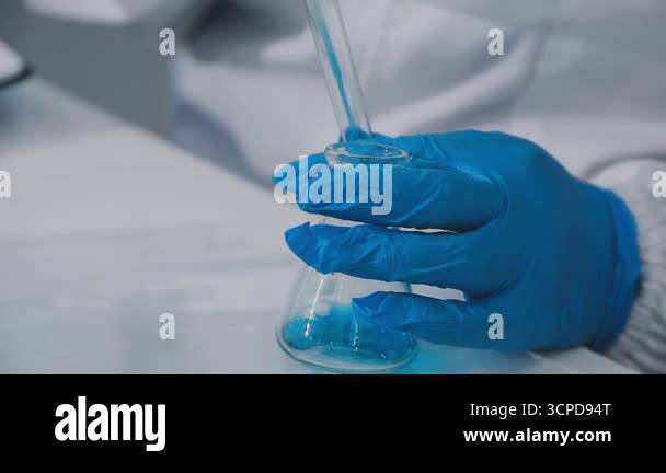 close up of scientist hand holding test tube with liquid in laboratory ...