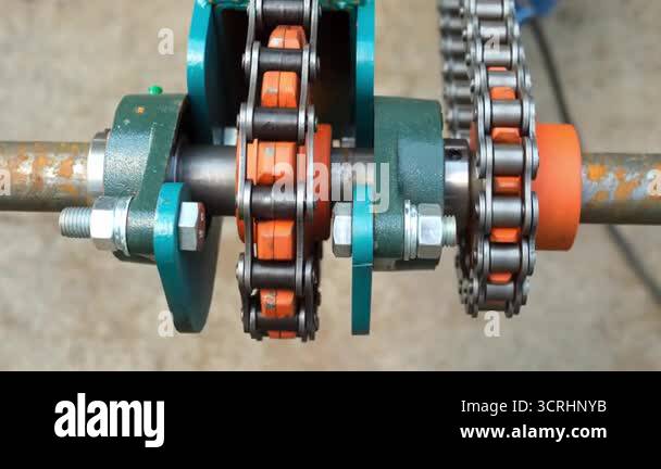 Rotating Hogs Chain Rall Gear wheels rotating metal chains on industrial automated equipment on ...