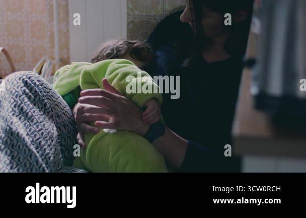 Mother breastfeeding baby in kitchen, intimate moment of maternal care ...