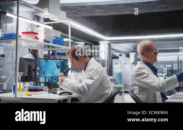 Male science expert operates with microscope and laboratory tray ...