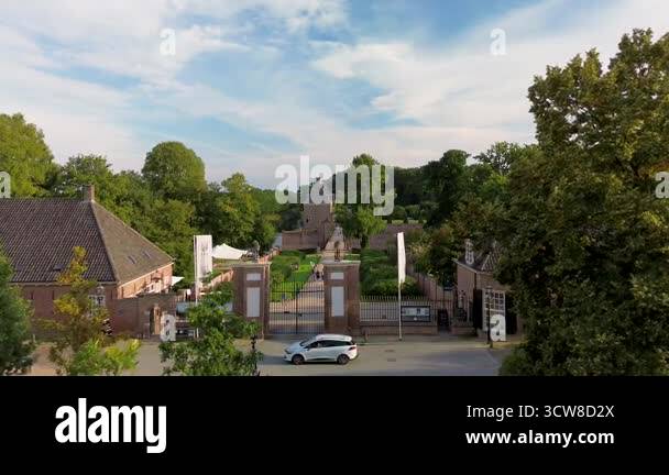 Aerial view of a historic castle surrounded by water, lush greenery ...