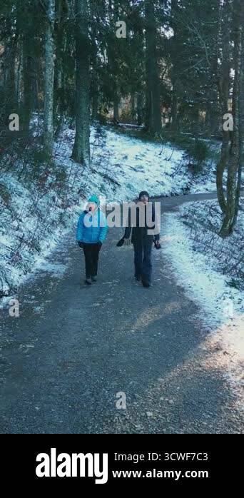 Happy smiling couple walking in winter forest. Smiling cheerful friends ...