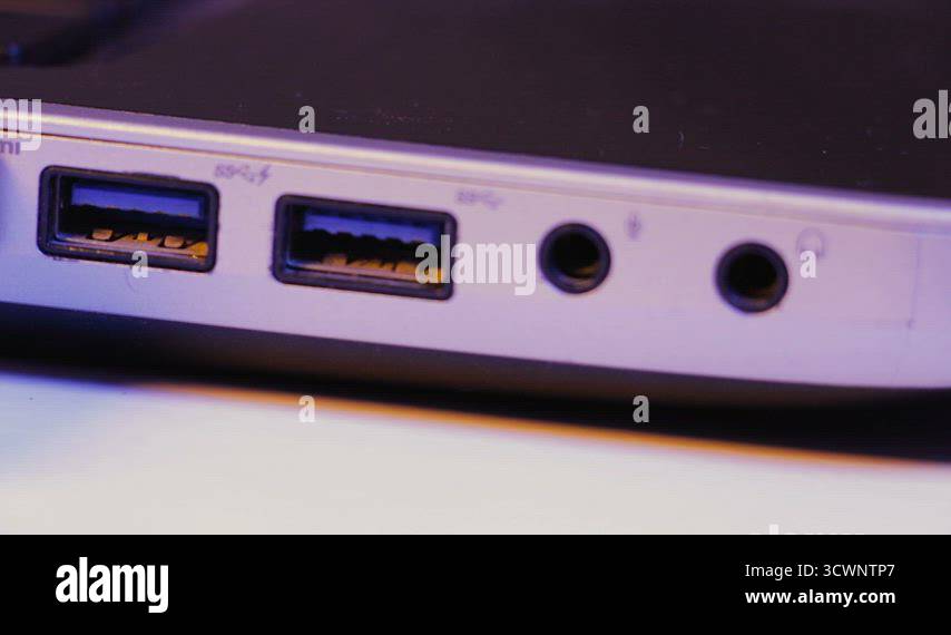 Closeup of HDMI cable plug inserted into port on the side of a laptop ...