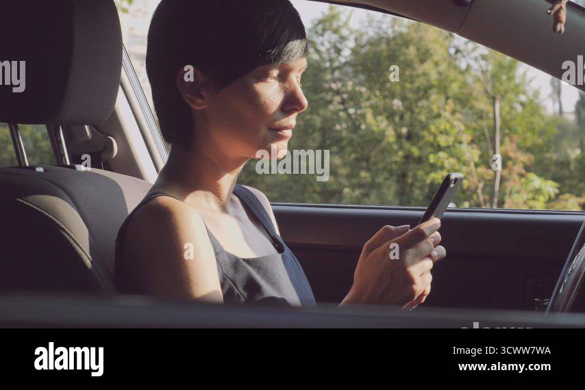 Friendly driver girl scrolling screen mobile Stock Video Footage - Alamy