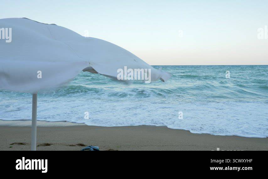 Beach umbrella in the wind Stock Video Footage - Alamy