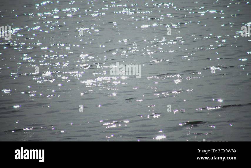 Glare on the water of the lake, the reflection of the sun in the water ...