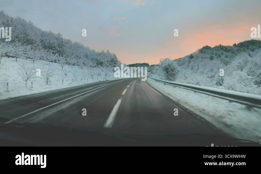 Snow Fast Moving Winter mountain road snow fast motion at sunrise. Driving a car on ...
