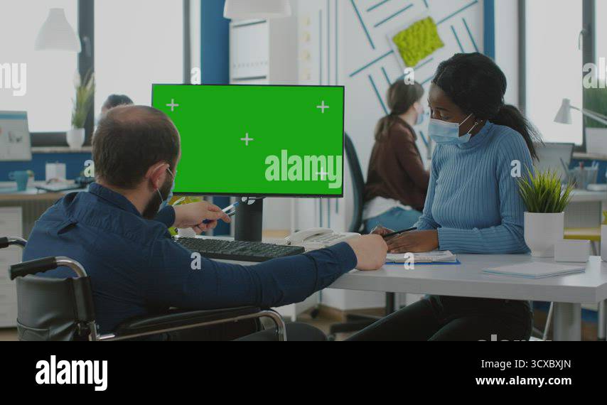 Manager with face mask typing on pc with green screen discussing with ...