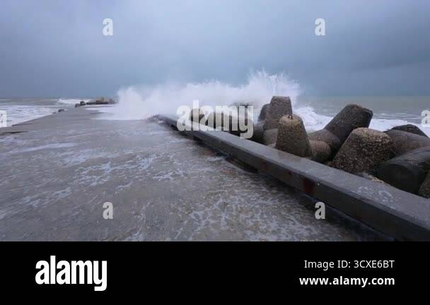 Powerful storm waves crashing against a pier, first-person view of ...