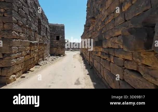 Shellstone Syria Ancient stone ruins with a cobblestone path under a clear blue sky ...