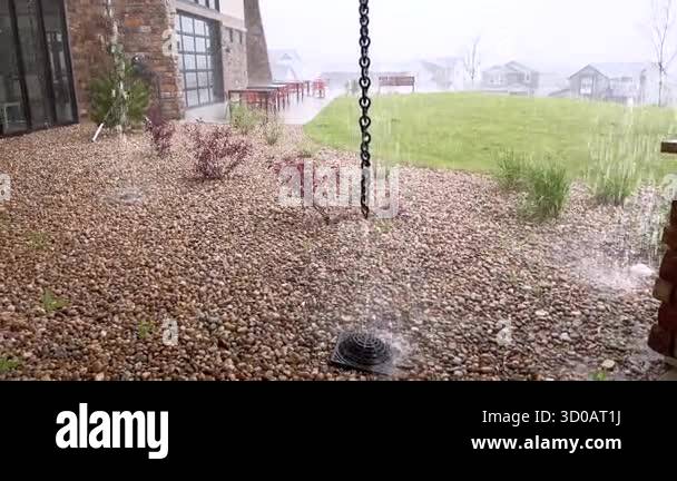 Rainwater flows into a backyard gravel drain connected to a vertical ...