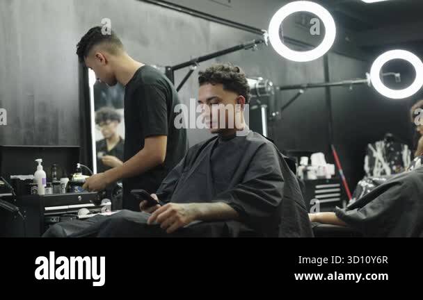 Light For Razor Barber Young barber trimming a clients curly hair with an electric razor. A ...