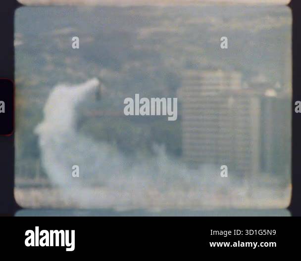 Archival footage in 8mm format depicting the controlled implosion of a ...