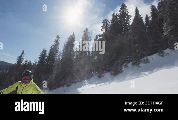 Skier enjoys the thrill of gliding down fresh powder slopes, surrounded ...