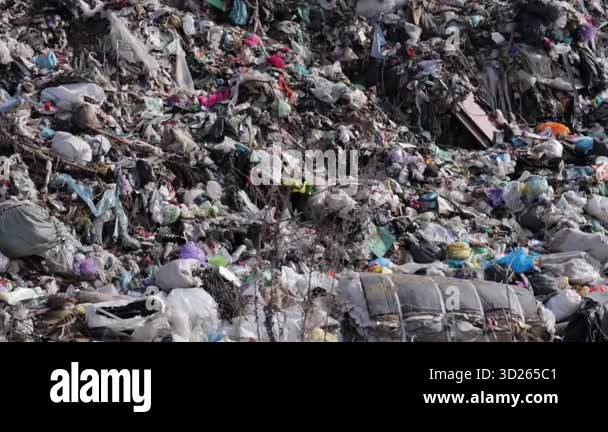 A large landfill overflowing with garbage including plastic and waste ...