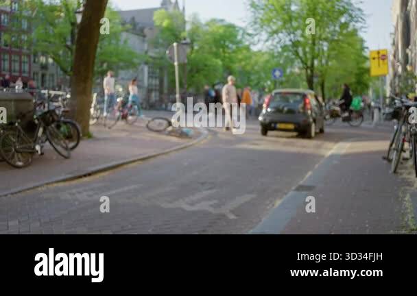 Urban street scene in amsterdam with blurred pedestrians and bicycles ...
