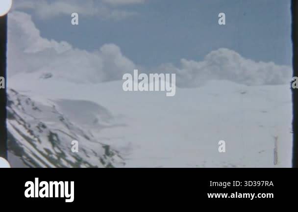 A sweeping view of snow-covered mountains, captured on 8mm film ...
