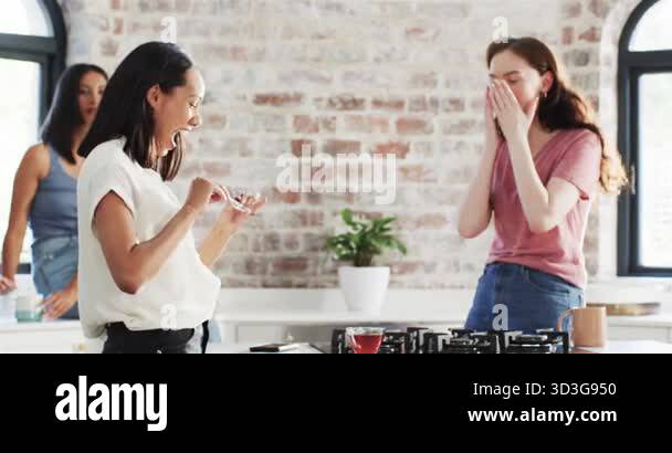 Hearing pregnancy news, Diverse female friends reacting in kitchen ...