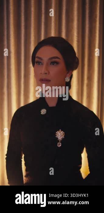 Elegant woman in black dress with vintage earrings posing before a