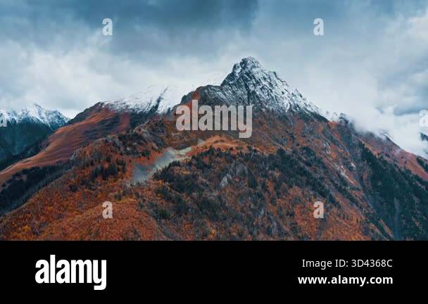 Snowy mountain landscape transitions through autumn colors Stock Video ...