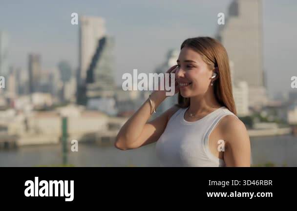 Portrait of joyful woman with loose hair dances walking along megapolis ...