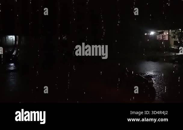 Heavy Close up slow motion shot of heavy rain falling hard on a dark ...