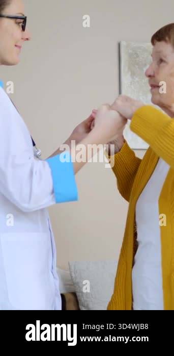 Compassionate young female doctor comforting and supporting a senior ...