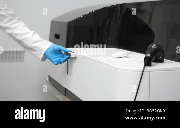 Medical laboratory technician in blue gloves inserting rack with test ...