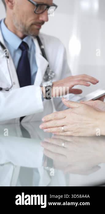 Doctor consulting patient across glass table, offering professional ...