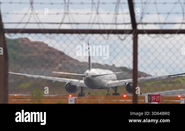 Slow motion footage of a plane taking off, view through an airport ...