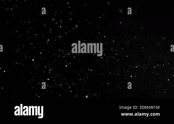 Particles and dust in the air on a black background. Filmed on a high ...