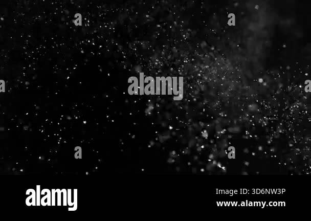 Particles and dust in the air on a black background. Filmed on a high ...