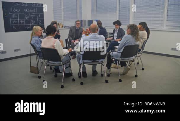 Diverse Group of Adult Students Sits in Circle Inside Modern Classroom ...